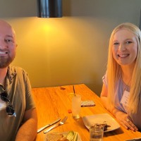 GVSU Alumni smile in booth after eating dinner together